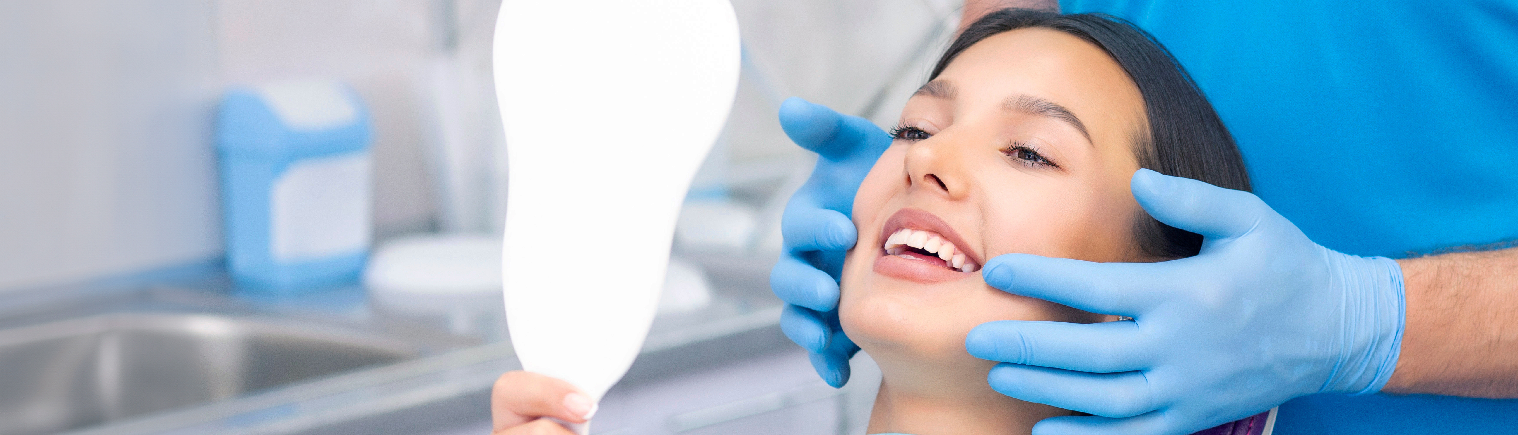 A well-lit reception area with a desk, computer monitor, and potted plant.